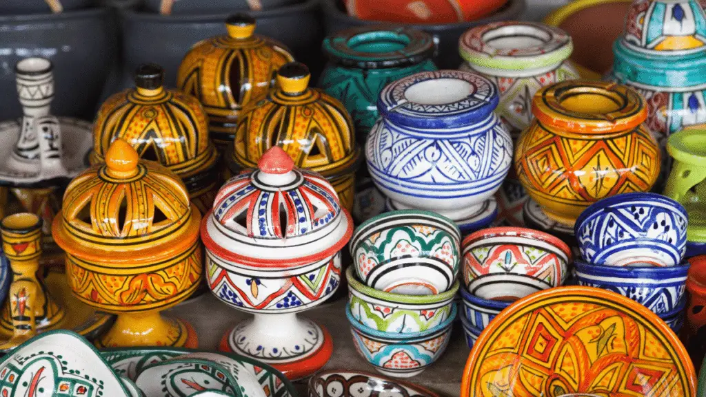 Cerámica marroquí: cuencos y pequeños tajines pintados en colores vivos apilados en un puesto